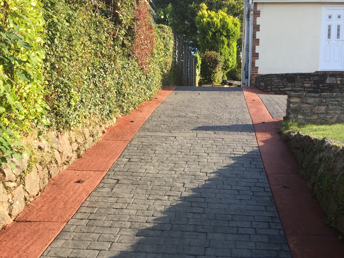 imprinted concrete long driveway with hedge